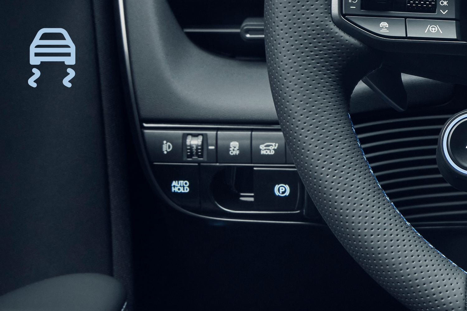 Close-up of a Hyundai vehicle's interior, showing traction control and other driving assist buttons near the steering wheel.
