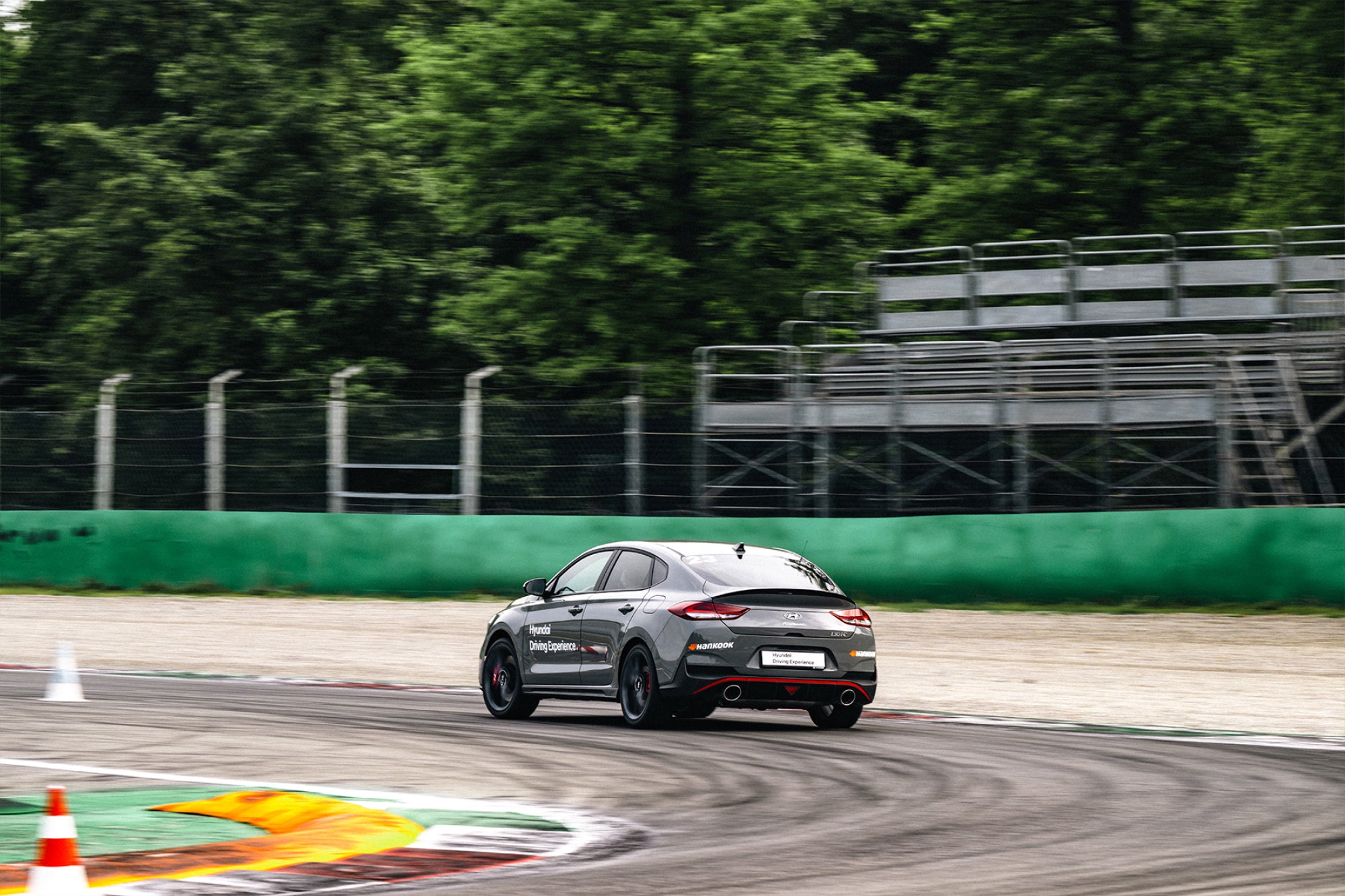 A dark grey Hyundai i30N driving on the Monza circuit curve

